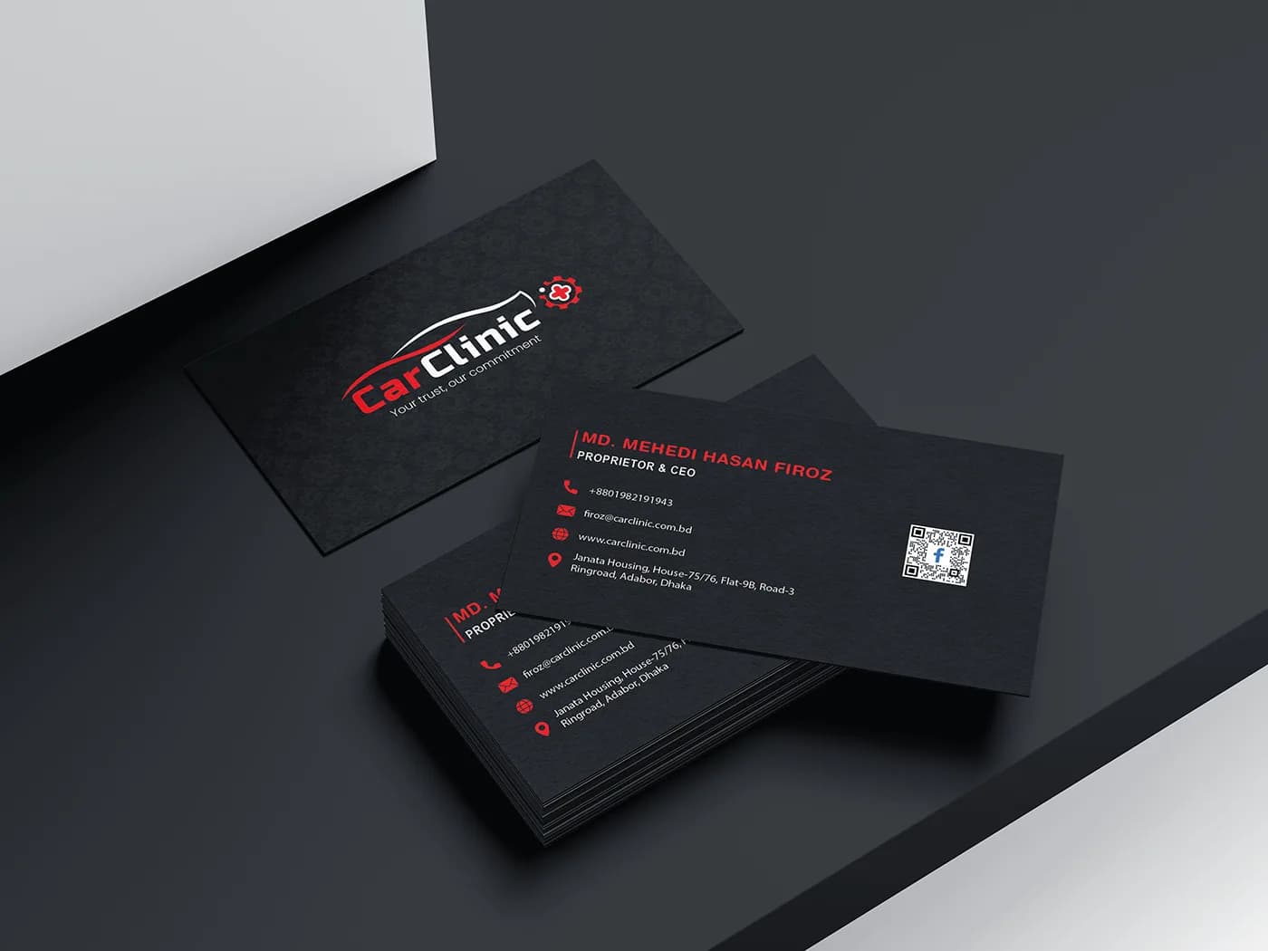 Black CarClinic business cards with red accents on a dark surface